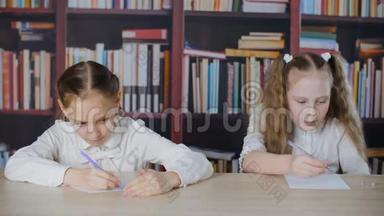 在书架背景下，女学生在学校考试中从<strong>作弊</strong>单上写作。 两个学生女孩解决<strong>作弊</strong>问题