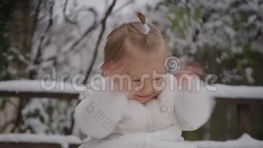 喜笑颜开的宝贝女孩坐在雪地公园.. 小男孩享受第一场雪。