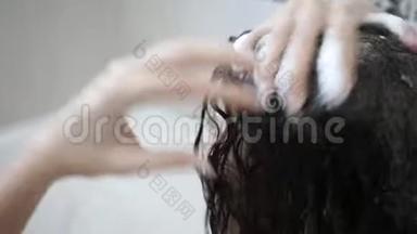女人用洗发水洗头。 头发护理，美容理念