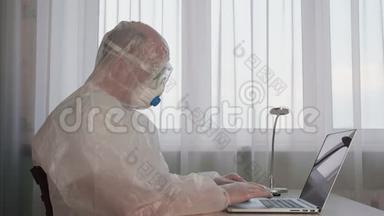 <strong>防疫</strong>检疫时穿着防护服装的办公室人员在手提电脑上工作。 穿白色防护服的男人