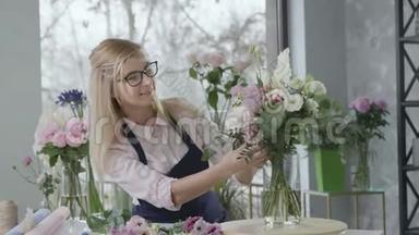 年轻的幸福女子花店做了一个现代花束在花店出售，女企业家，一个代表
