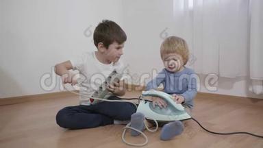 家里的危险情况，孩子们坐在地板上玩电，手里拿着电源插座，腿上拿着法兰盘