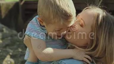 漂亮的年轻妈妈和活泼可爱的金发男孩在玩，玩得很开心。 女人爱她的儿子。 漂亮的年轻妈妈