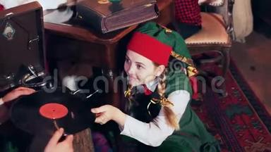一个穿绿色西装的小精灵女孩给一个小精灵唱片
