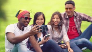 朋友学生坐在大学背景下，在朋友智能手机上<strong>观看</strong>有趣的<strong>视频</strong>