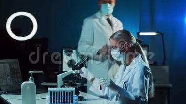 在实验室工作的医学科学家。教授实习生进行血液分析研究的医生。实验室工具：显微镜