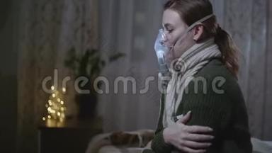 戴暖和围巾的生病女孩在家里坐在床上测量体温和吸入面罩