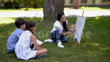 两个孩子坐在一棵绿草上向一位老师<strong>问好</strong>。