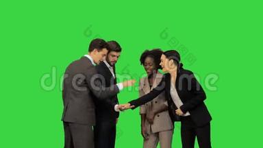 不同的成人商务人士携手合作，<strong>团队精神</strong>在一个绿色屏幕，Chroma键。