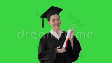 毕业的女人微笑着，在<strong>绿色</strong>的屏幕上看着快乐，Chroma键。