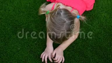 小女孩在草地上，手在草地上