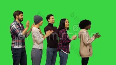 快乐的年轻人在绿色屏幕上拍手，Chroma键。