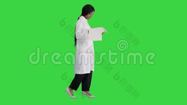 美国黑人<strong>医</strong>生妇女走<strong>路</strong>和看心电图记录在绿色屏幕，Chroma键。