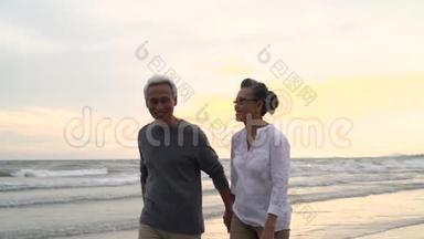 亚洲夫妇老年退休休息放松<strong>牵手散步</strong>日落海滩蜜月家庭在一起