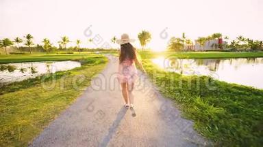 跟随我的概念，年轻的女人跑在热带高尔夫球场的道路上。 <strong>暑假</strong>或<strong>假期</strong>