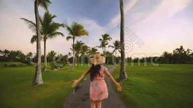 跟随我的概念，年轻的女人跑在热带高尔夫球场的道路上。 暑假或假期