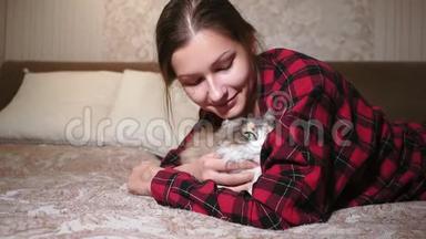 年轻女孩肖像特写躺在床上抚摸一只猫，宠物。 真实的<strong>视频</strong>，<strong>友谊</strong>，爱情，安慰