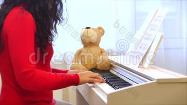 一名学生或专业钢琴家在一架漂亮的白色钢琴上演奏<strong>古典音乐</strong>，钢琴家的手