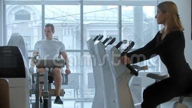 现代健身房-年轻男女训练白色现代健身房大全景镜