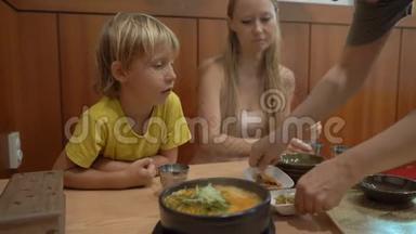 一家人在餐馆里享用<strong>传统</strong>的<strong>韩国</strong>食品面条和Kimpa