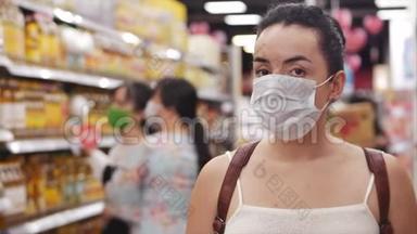 戴着冠状病毒流行面具的年轻女子站在超市的<strong>杂货店里</strong>，那里的人们