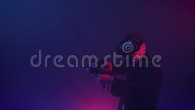 虚拟现实中的男青年玩家在网上射击游戏中使用控制器射击网络霓虹灯