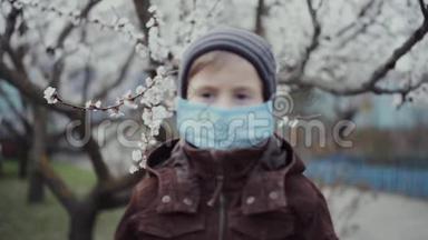 一个5岁的孩子戴着医学面具在一棵开花的树的背景上。