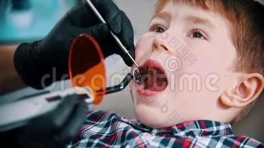 一个小男孩把他的牙齿做好了-把光聚合物灯放进嘴里，然后打开它