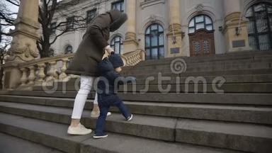 小男孩在国家艺术博物馆的楼梯上，妈妈牵着他的手。 慢动作