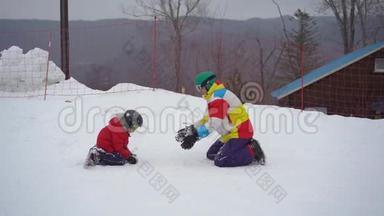 一个年轻人和他的小儿子在一个山区度假活动公园的滑雪坡上玩得很开心。 寒假概念