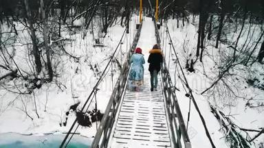 两个女朋友在冬天的森林里的雪桥上<strong>喝</strong>着<strong>热水</strong>瓶里的热饮料
