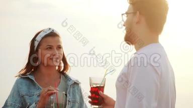 一个男人和一个女孩在一个鸡尾酒会上站在屋顶，喝着夏天的城市鸡尾酒和交谈。 慢动作