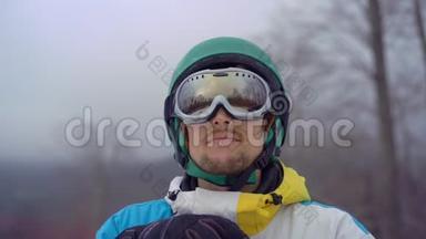 特写镜头，一个穿着雪谷歌的年轻人看着山坡。 寒假概念。 慢镜头