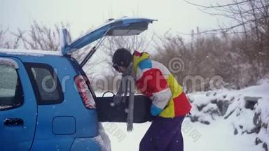 一个年轻人试图把他的滑雪板装在一辆<strong>小汽车</strong>里，但他`不到。 汽车空间不足的概念