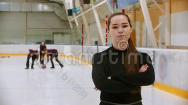 卷曲训练-法官站在冰场上看镜头-她的学生在冰上卷曲。