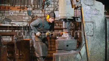 锻造工业-一个铁匠把铁块置于大机器的压力下