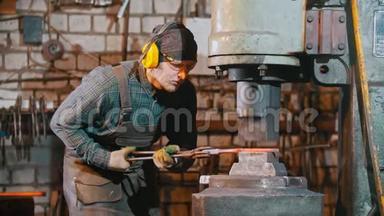锻造工业-一个铁匠把铁块置于大机器的压力下-制造一把刀