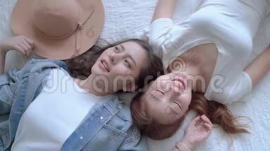 两个美丽的亚洲女孩的顶级<strong>视频</strong>，谁是朋友，躺在床上聊天，心情愉快。 <strong>友谊</strong>的概念