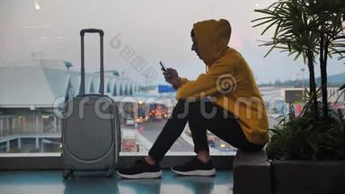 戴头巾的旅客剪影，行李在机场候机楼等候，旅客使用