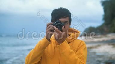 晚上，穿黄色连帽衫的男<strong>摄影</strong>师在美丽的<strong>热带</strong>海滩上拍照
