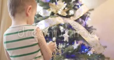 <strong>小男孩</strong>或孩子在圣诞树上挂<strong>新年</strong>`玩具，装饰圣诞树。 圣诞节