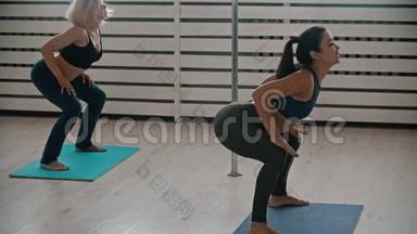 两个<strong>运动</strong>妇女在健身训练中热身-弯曲她们的<strong>腰部</strong>