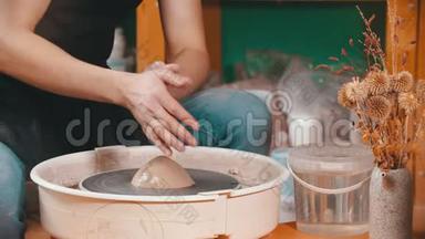陶器-主人正在润湿粘土以更好地滑行