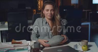 满意的女商人关闭她的笔记本电脑，戴着<strong>颈枕</strong>，试图睡觉。 年轻妇女办公室工人