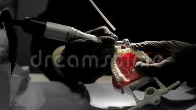 一个牙医的特写<strong>练习</strong>用钻床模拟牙齿骨架。 牙医巧妙地<strong>练习</strong>