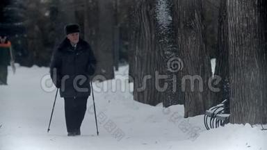 年迈的祖父-快乐的祖父在冬季<strong>公园里</strong>从事北欧<strong>散步</strong>