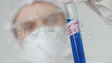 一个戴<strong>防</strong>护<strong>眼镜</strong>和面罩的女孩检查一个带有危险病毒标记的<strong>蓝</strong>色液体的试管。 A.