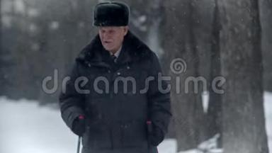 老爷爷-体贴的爷爷正在冬季公园里的北欧漫步