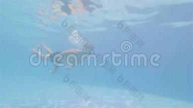 运动员在水中游泳，在漂浮的游泳池里训练。 水下观景人在清澈的蓝色海水中游泳