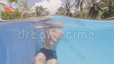 年轻的游泳运动员从度假酒店水线景观的室外游泳池出来。 坐在池边的胡子男